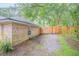 Side view of brick home and gravel driveway leading to a fenced backyard at 1500 Wyngate Dr, Deland, FL 32724
