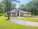Charming single-story brick home with well-manicured landscaping and a circular driveway surrounded by mature trees at 1500 Wyngate Dr, Deland, FL 32724
