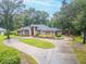 Attractive single story brick home featuring a circular driveway, well-maintained landscaping and mature trees surrounding property at 1500 Wyngate Dr, Deland, FL 32724