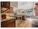 Bright kitchen with wood-look floors, dark wood cabinets, and a granite countertop island at 1500 Wyngate Dr, Deland, FL 32724