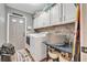 Laundry room with modern appliances, overhead cabinets and rustic design at 1500 Wyngate Dr, Deland, FL 32724
