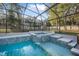 Relaxing screened pool with a built-in hot tub and waterfall feature at 1500 Wyngate Dr, Deland, FL 32724