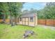 Backyard shed with painted wood, metal roof, and double doors at 1500 Wyngate Dr, Deland, FL 32724