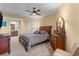 Comfortable bedroom with a ceiling fan, neutral carpet, and a view into the en suite bathroom at 1900 N Atlantic Ave # 1603, Daytona Beach, FL 32118
