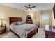 Cozy bedroom featuring a ceiling fan, neutral carpet, and a window offering natural light at 1900 N Atlantic Ave # 1603, Daytona Beach, FL 32118
