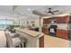 Spacious kitchen featuring stainless appliances, bar seating, and adjacent living area with ocean view at 1900 N Atlantic Ave # 1603, Daytona Beach, FL 32118