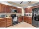 Kitchen featuring wood cabinets, granite countertops, stainless microwave, and black appliances at 1900 N Atlantic Ave # 1603, Daytona Beach, FL 32118