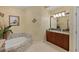 A bright bathroom with a garden tub, mosaic tile accents, and dual vanity sinks at 1925 S Atlantic Ave # 201, Daytona Beach, FL 32118
