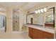 A clean bathroom with a step in shower, large mirror, and vanity with granite countertop at 1925 S Atlantic Ave # 201, Daytona Beach, FL 32118