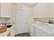 Functional laundry room with sink, washer, dryer, and storage cabinets at 1925 S Atlantic Ave # 201, Daytona Beach, FL 32118
