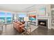 Living room with a fireplace, leather furniture and sliding doors overlooking the ocean and outdoor patio at 1925 S Atlantic Ave # 201, Daytona Beach, FL 32118