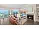 Well-lit living room features a fireplace, leather furniture, and sliding glass doors overlooking the ocean and outdoor patio at 1925 S Atlantic Ave # 201, Daytona Beach, FL 32118