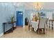 Dining room featuring chandelier, blue accent wall, and open access to the entry at 1957 Monterey Dr, Deltona, FL 32738