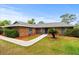 Charming single-story brick home featuring a well-maintained lawn and cozy front entrance at 1957 Monterey Dr, Deltona, FL 32738