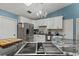 Open kitchen showcasing granite counters, cooktop island, stainless appliances, and bright cabinets at 1957 Monterey Dr, Deltona, FL 32738