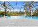 Beautiful screened-in swimming pool with backyard trees and lake view at 1957 Monterey Dr, Deltona, FL 32738
