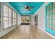 Enclosed sunroom features tile flooring, a ceiling fan, and ample natural light from the large windows at 1957 Monterey Dr, Deltona, FL 32738