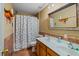 Bathroom features a double sink vanity, decorative mirror, tiled walls, and a shower with a patterned curtain at 1978 S Old Mill Dr, Deltona, FL 32725