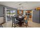 Kitchen and eat-in space with wood cabinets, stainless appliances, pendant lighting, and a sliding door to the backyard at 1978 S Old Mill Dr, Deltona, FL 32725