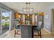 Eat-in kitchen with wood cabinets, stainless appliances, pendant lighting, and a sliding door to the backyard at 1978 S Old Mill Dr, Deltona, FL 32725