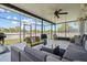 Inviting screened-in porch with comfortable seating, ceiling fans, and an outdoor view, perfect for relaxation at 1978 S Old Mill Dr, Deltona, FL 32725