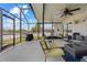 Inviting screened-in porch with comfortable seating, ceiling fans, and an outdoor view, perfect for relaxation at 1978 S Old Mill Dr, Deltona, FL 32725