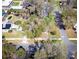 Aerial view of a home with a green yard, driveway, and surrounding greenery at 201 W Central Ave, Orange City, FL 32763