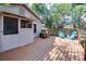 Cozy back deck featuring painted wood, railings, outdoor chairs, and tree-lined yard at 201 W Central Ave, Orange City, FL 32763