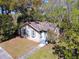 Charming bungalow exterior featuring a sidewalk, blue door, green grass, and surrounding trees at 201 W Central Ave, Orange City, FL 32763