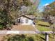 Charming bungalow exterior featuring a sidewalk, blue door, green grass, and surrounding trees at 201 W Central Ave, Orange City, FL 32763