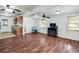 Bright living room featuring hardwood floors, a ceiling fan, fireplace and an open kitchen at 201 W Central Ave, Orange City, FL 32763