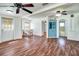 Open living room featuring wood floors, ceiling fans, and a charming blue china cabinet at 201 W Central Ave, Orange City, FL 32763