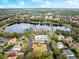 Beautiful aerial view of community lake, clubhouse, and pool nestled among lush greenery under a partly cloudy sky at 203 W Tarrington Dr, Deland, FL 32724
