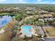 Aerial view of the community pool surrounded by trees, walkways, parking, and homes at 203 W Tarrington Dr, Deland, FL 32724