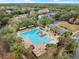 Aerial view of community pool with lush trees, walkways, and parking, next to the clubhouse at 203 W Tarrington Dr, Deland, FL 32724