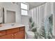 Bathroom with a vanity, toilet, and shower/tub combo with leaf-patterned curtain at 203 W Tarrington Dr, Deland, FL 32724