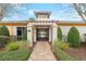 Gated entrance to the community clubhouse features stone pillars, mature landscaping, and a well-maintained brick pathway at 203 W Tarrington Dr, Deland, FL 32724