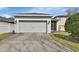 Attached garage with a driveway and an adjacent screened-in porch at 203 W Tarrington Dr, Deland, FL 32724
