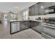 Modern kitchen featuring stainless steel appliances, dark cabinets, and granite countertops at 203 W Tarrington Dr, Deland, FL 32724