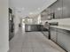 Open concept kitchen with stainless steel appliances, gray cabinetry and tile floors at 203 W Tarrington Dr, Deland, FL 32724