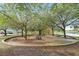Relaxing park area with picnic tables and benches, surrounded by mature trees and a paved walking path near the lake at 203 W Tarrington Dr, Deland, FL 32724