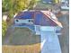 Aerial view of a charming single Gathering home with solar panels on the roof and a concrete driveway leading to the garage at 2129 E Gloria Dr, Deltona, FL 32725