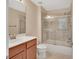 Bathroom featuring tub with glass doors and a cherry wood vanity at 214 Woodhouse Ln, Deland, FL 32724