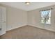 This is a spacious bedroom with neutral walls, carpet, and a bright window at 214 Woodhouse Ln, Deland, FL 32724
