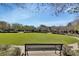 Community green featuring a large grassy area, mature trees, benches and well-maintained landscaping at 214 Woodhouse Ln, Deland, FL 32724