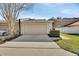 Beige garage and driveway showcasing an attached unit with manicured landscaping and ample parking at 214 Woodhouse Ln, Deland, FL 32724