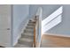 Carpeted staircase with wooden handrail, providing a transition between levels of the home at 214 Woodhouse Ln, Deland, FL 32724