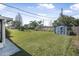 Large backyard with ample space, including a shed, lush grass, and scattered trees at 2216 Umbrella Tree Dr, Edgewater, FL 32141