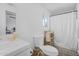 Bright bathroom featuring a toilet, a vanity with sink, a mirror and a shower at 2216 Umbrella Tree Dr, Edgewater, FL 32141