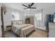Well-lit bedroom featuring a ceiling fan, wood floors, and natural light from two windows at 2216 Umbrella Tree Dr, Edgewater, FL 32141